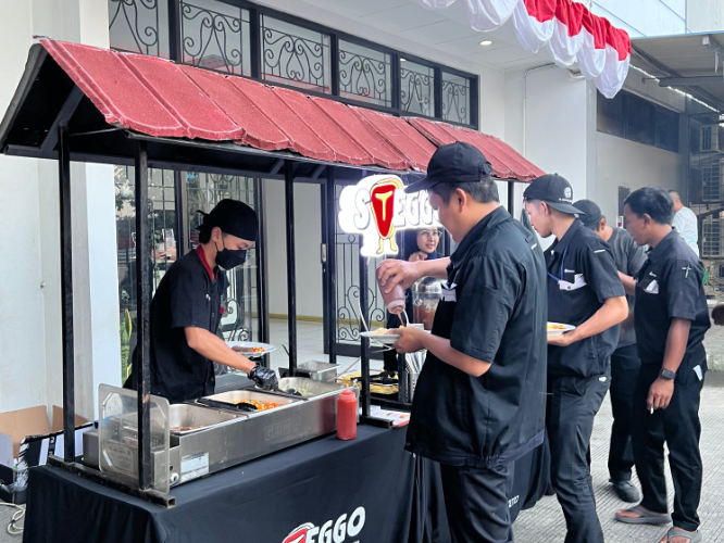 Karyawan mengambil makanan di stall live cooking Steggo saat acara perusahaan